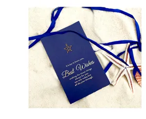 Dettaglio di un elegante biglietto di auguri blu con ciondolo a stella e nastro