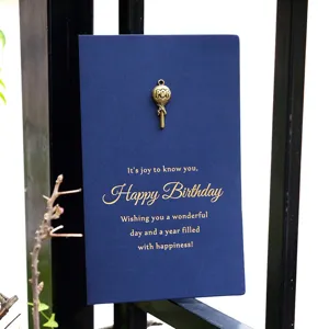 Vintage blue birthday card featuring gold foil text and a unique metal lollipop pendant charm.