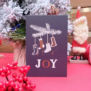 Biglietto di auguri natalizio festivo con scritta JOY e illustrazioni di calze