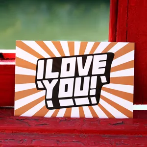 Tarjeta artística de San Valentín con texto I LOVE YOU en un alféizar de madera roja