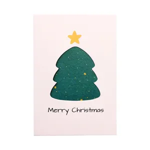 Minimalist white Christmas card with green hollow tree and gold star design