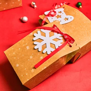 Christmas kraft paper gift boxes with red ribbons and snowflake tags