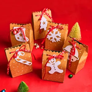Set of Christmas kraft paper gift bags with white holiday cutouts and red ribbons