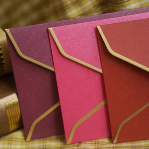 Élégantes enveloppes nacrées avec bordure dorée pour des invitations d'affaires haut de gamme