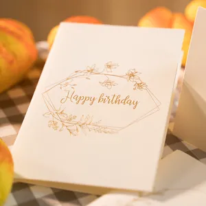 Biglietto di auguri vintage con corona floreale in oro e busta coordinata.
