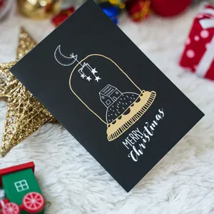 Biglietto di auguri natalizio nero creativo con casa in lamina d'oro e busta abbinata