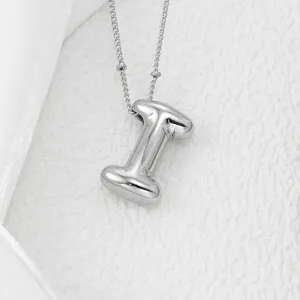 Collier pendentif lettre argenté volumineux, style bijou hip-hop minimaliste et tendance.