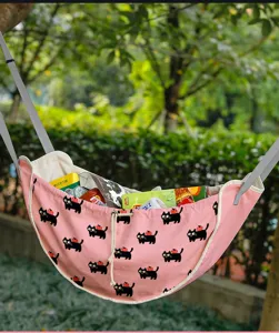 Detail van roze auto-organizer voor de achterbank met zwarte kattenprint en snacks