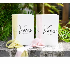 Close-up of elegant wedding vow cards with gold foil lettering and silk ribbon set