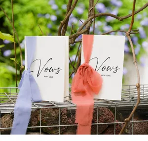 Detailed view of elegant paper wedding vow cards with lavender and coral ribbons