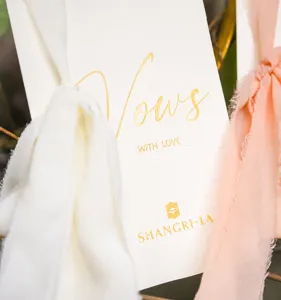 Detail showing gold foil Vows lettering on luxury wedding vow card with soft ribbon