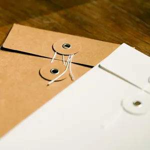 Vintage kraft paper envelopes with string and button tie closure on wood