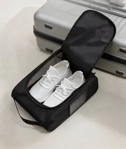 Detalle de zapatillas blancas en una bolsa organizadora de zapatos de viaje negra