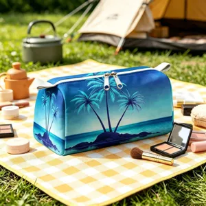 Borsa da trucco con stampa palma tropicale esposta su un tappeto da picnic all'aperto