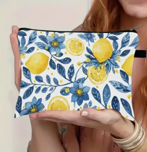 Close-up detail of lemon and floral print makeup bag held in hand for size demonstration