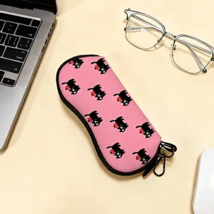 Close-up of pink portable glasses case with cute black cat pattern on office desk surface