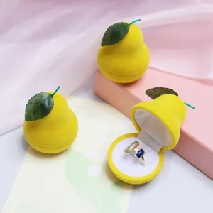 Close-up detail of cute pear velvet ring box with green leaf, ideal jewelry storage display.