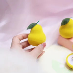 Close-up view of the cute yellow pear shaped ring box with soft velvet texture and green leaf detail.