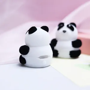Détail en gros plan de la boîte à bague en velours panda, texture douce pour bijoux.