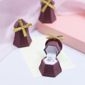 Detailed view of a cute windmill velvet ring box in purple with gold blades for jewelry storage.