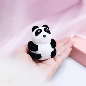 Gros plan d'une jolie boite a bague panda dans la main, ideale pour presentation et cadeaux.