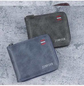 Detailed macro shot of two men's short zippered wallets in denim blue and charcoal grey