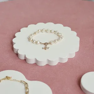 Elegante bracciale di perle d'acqua dolce con pendente luminoso e chiusura su supporto.