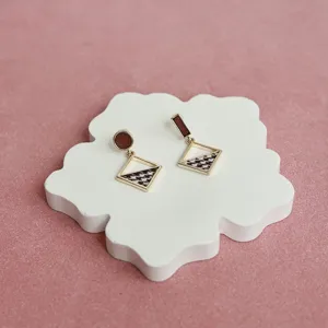 Orecchini geometrici asimmetrici con motivo pied de poule e montatura in metallo dorato chic.