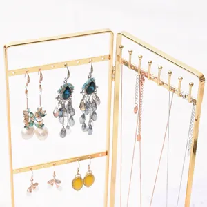 Gold metal jewelry display stand detail showing hooks and multi-tier hanging design.