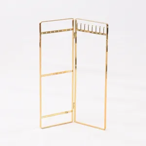 Close-up detail of vintage gold jewelry display stand, gold finish earring and necklace holder.