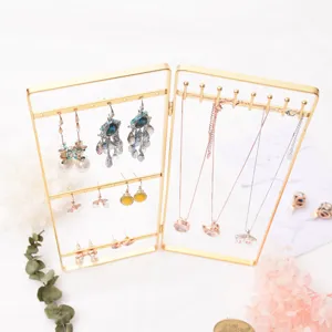 Vintage gold jewelry display stand for holding earrings, necklaces, and bracelets.