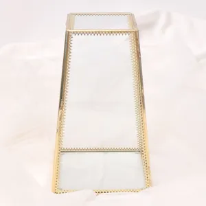 Geometric glass jewelry storage box with gold metal frame, clear display stand for accessories.