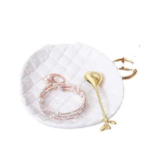 Nordic ceramic jewelry tray with pearl bracelet and gold leaf spoon for desktop storage display.