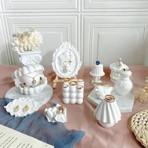 Gedetailleerd overzicht van creatieve witte gipsen sieraden display standaards, ketting en ring houder.