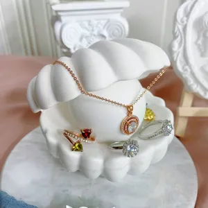 Close-updetails van prachtige sieraden gepresenteerd op een creatieve schelpstandaard.