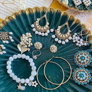 Vintage dark green jewelry tray set featuring pearl tassel earrings, rings, and turquoise studs.