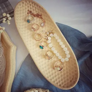 Elegante sieradenset met stijlvolle ringen en kralenarmband op gestructureerd ovaal dienblad.