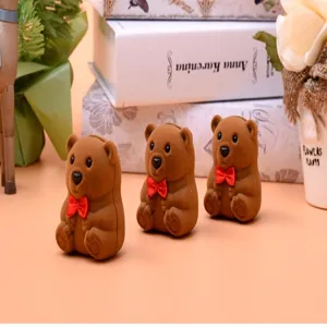 Süße braune Bär Flockring Schmuckschatulle Detailaufnahme, weiche Textur mit roter Schleife.
