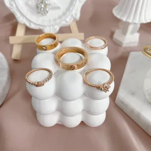 Elegante roségouden metalen ringen met klassiek schroefmotief en kristallen inleg.