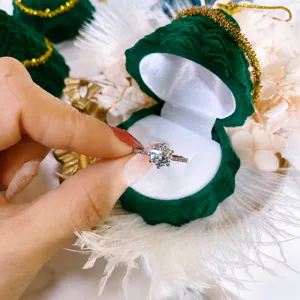 Eleganter Sechserkrappen-Diamantring kombiniert mit einer grünen Weihnachtsbaum-Schmuckbox.