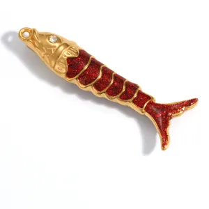 Detailweergave van een visvormige hanger met rode glitters en gouden plating