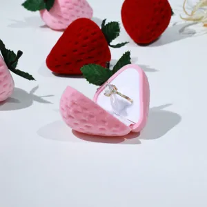 Close-up of a cute strawberry velvet ring box detail, showing soft pink flocked surface and interior.