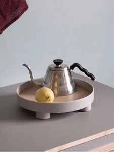 Minimalist stainless steel gooseneck drip kettle and round wooden tray home decor display prop.