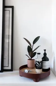 Detailed view of the round decorative storage tray with short feet, styled on a minimalist table.