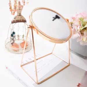 Rose gold desktop makeup mirror with elegant round frame and metal stand for vanity display.