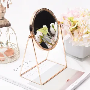 Detailed close-up of a stylish European-style rose gold tabletop makeup mirror with a metal frame.