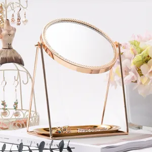 Copper desktop cosmetic mirror with rotating design and storage tray for daily vanity makeup.