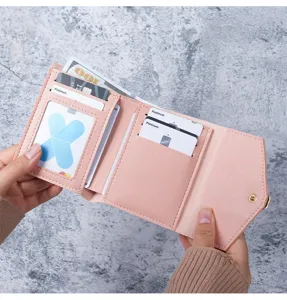 Close-up of pink trifold wallet interior showing multiple card slots and bill compartment.