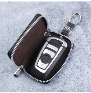 Detailed view of a compact black leather key case featuring a zipper and a metal hook