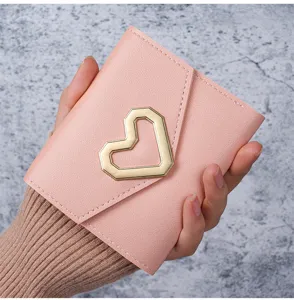 Close-up of a pink faux leather card holder featuring a gold heart-shaped buckle